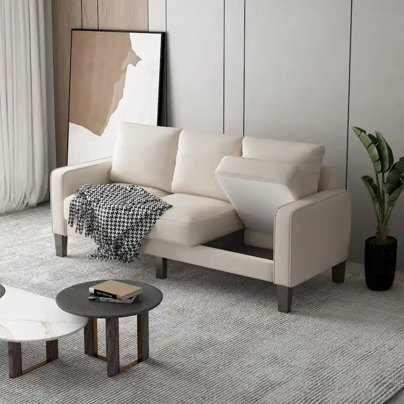 Beige stoffen bank met rechte armleuningen en gecapitonneerde rugleuning